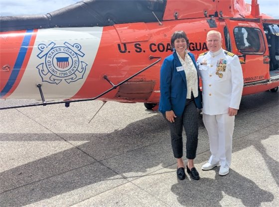 Supervisor Natalie Arroyo with Coast Guard Captain Scott Powers in front of Coast Guard helicopter