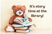 It's story time at the library. A teddy bear with a pile of books.