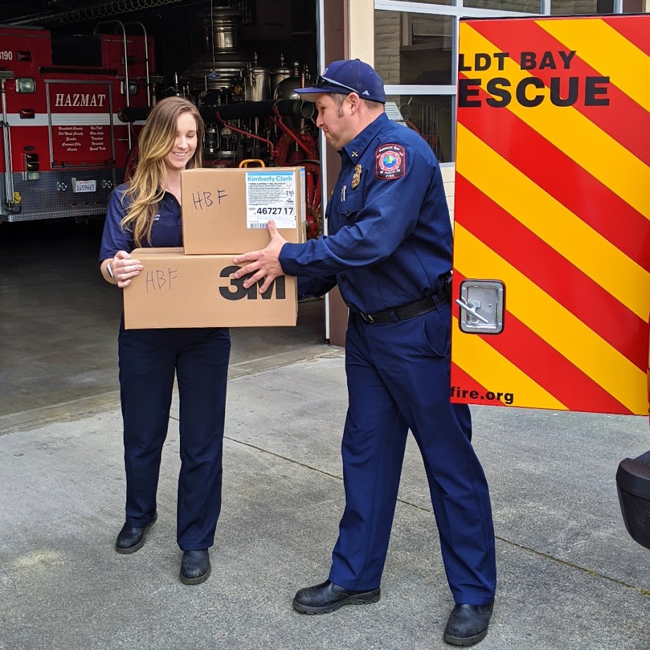 Battalion Chief Nick Launius hands off boxes of much-needed gear to Community Risk Reduction Special
