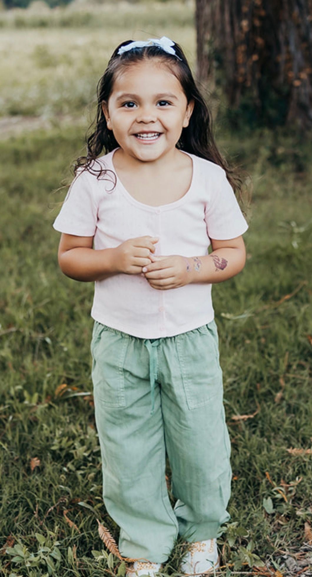 Full body length photo of 4-year old Thompson Thompson as she poses with a smile. 