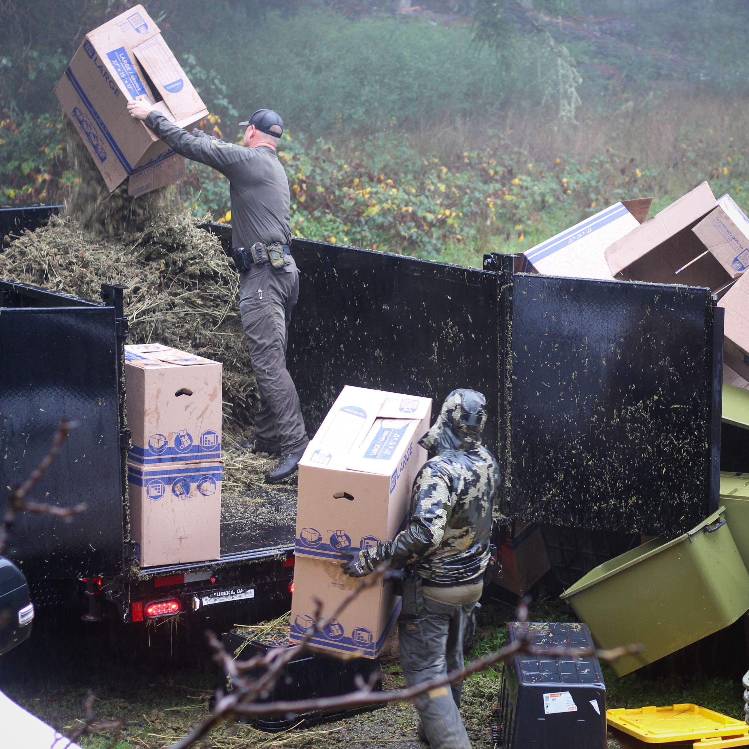Sheriff's Deputies dumping boxes of marijuana into a trailer