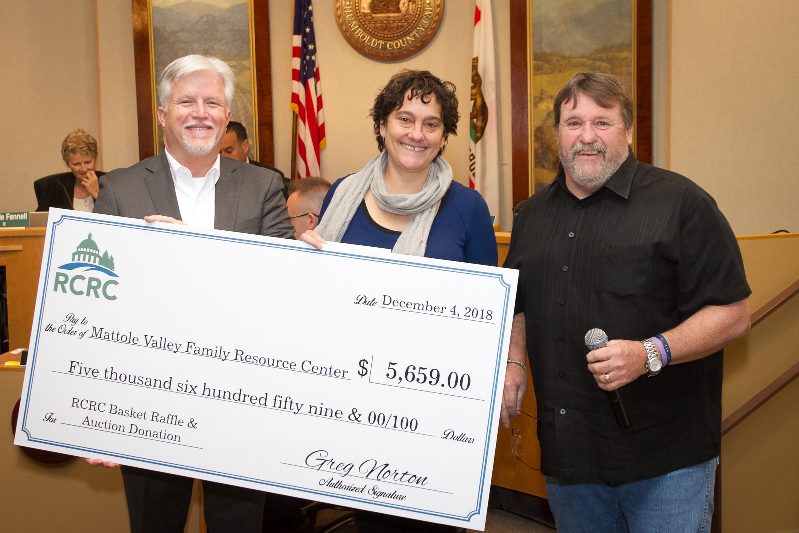 Supervisor Rex Bohn, right, and RCRC Chief Executive Officer Greg Norton, left, present Mattole Fami